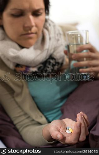 Sick woman taking pills for flu