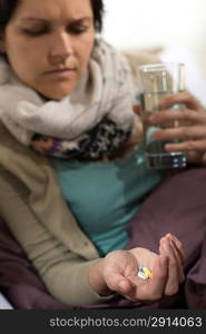 Sick woman taking pills for flu