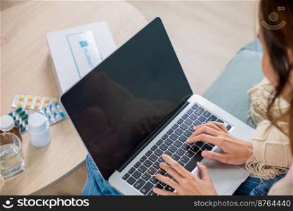 Sick young woman sit on sofa video call online with laptop consult with doctor at home, female covered blanket searching instructions for medical use medications in internet, healthcare and technology