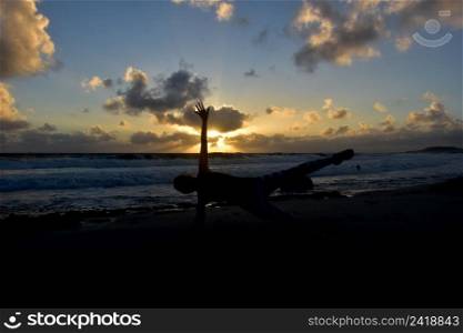 Side plank silhouetted on a beach at sunrise in Aruba.