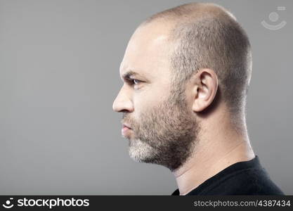 side portrait of gloomy man isolated on gray background with copyspace