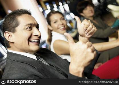 Side profile a mature man showing a thumbs up sign with his daughter beside him at a casino