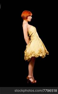 Side profile of a beautiful Caucasian redhead woman in yellow cocktail dress standing leaning backward, isolated