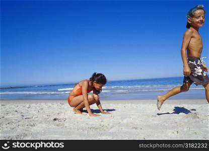 Side profile of a boy and a girl walking on the beach