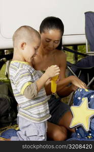 Side profile of a boy and his mother holding a flashlight