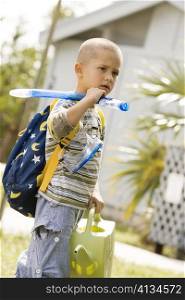 Side profile of a boy holding a watering can and snorkel