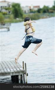 Side profile of a boy jumping into a lake