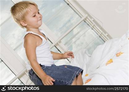 Side profile of a boy jumping on the bed