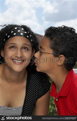 Side profile of a boy kissing a teenage girl