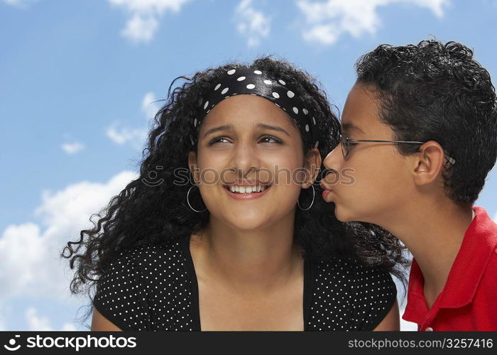 Side profile of a boy kissing a teenage girl