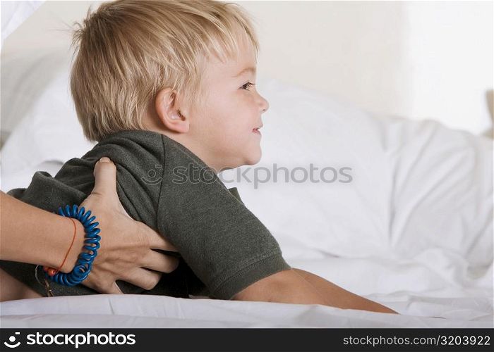 Side profile of a boy lying down on a bed