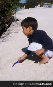 Side profile of a boy playing in sand