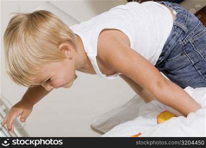 Side profile of a boy playing on the bed