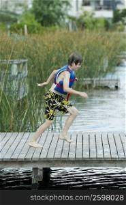 Side profile of a boy running on a pier