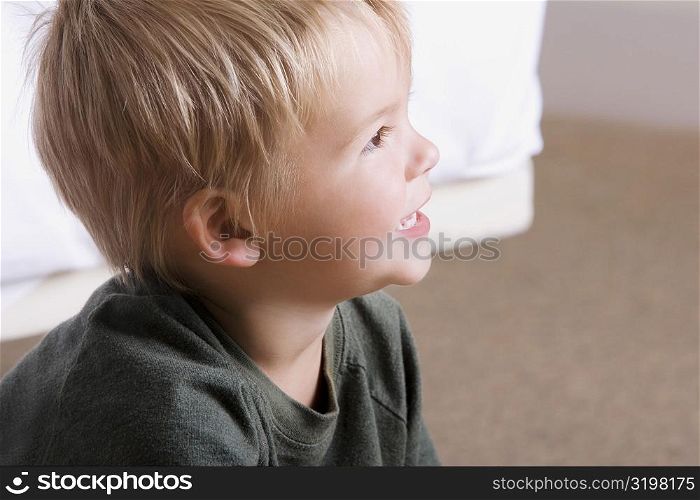 Side profile of a boy sitting on the floor