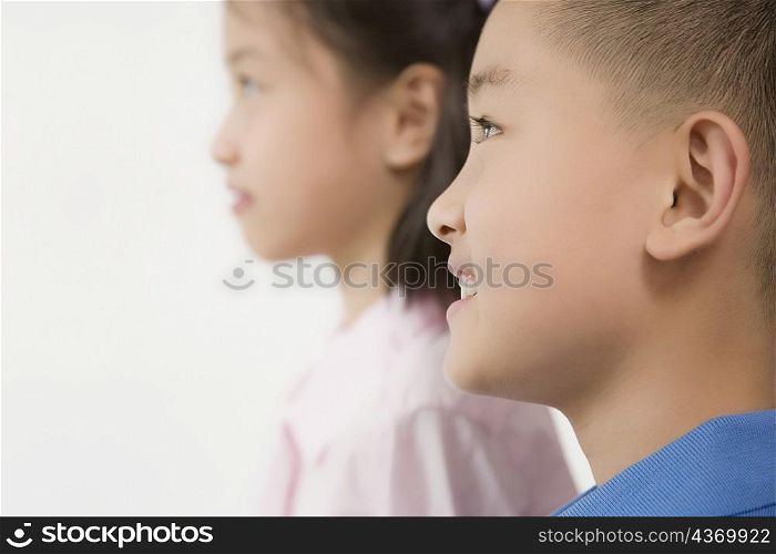 Side profile of a boy smiling with his sister