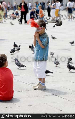 Side profile of a boy standing and wearing a mask, Venice, Veneto, Italy