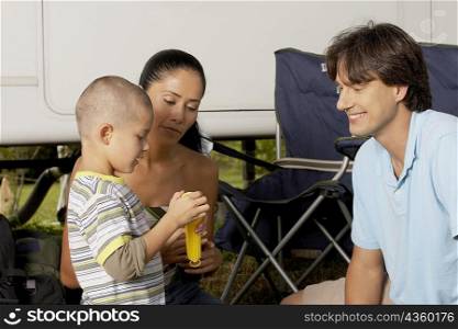 Side profile of a boy with his parents holding a flashlight