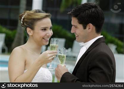 Side profile of a bride and her groom toasting with champagne flutes