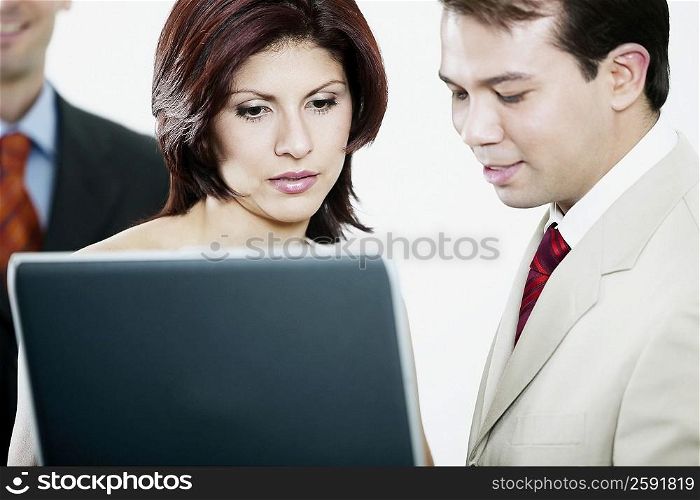 Side profile of a businessman and a businesswoman looking at a laptop