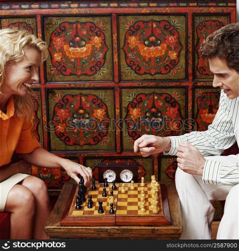 Side profile of a businessman and a businesswoman playing chess