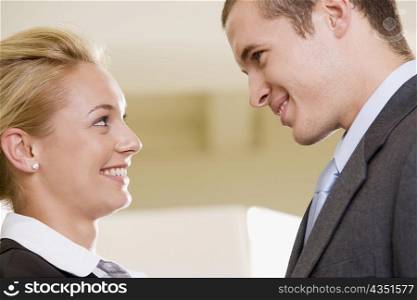 Side profile of a businessman and a businesswoman smiling