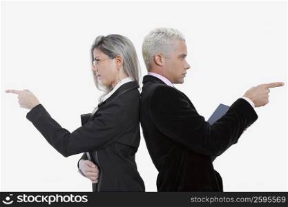 Side profile of a businessman and a businesswoman standing back to back and pointing