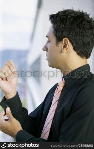 Side profile of a businessman getting dressed