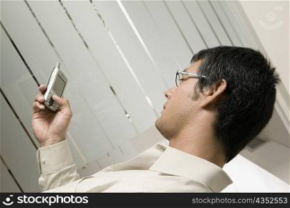 Side profile of a businessman holding a mobile phone