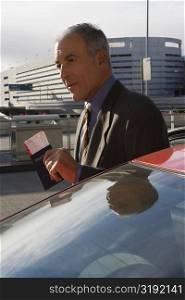 Side profile of a businessman holding a passport with an airplane ticket