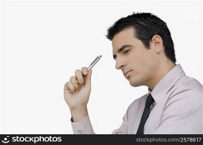 Side profile of a businessman holding a pen and thinking