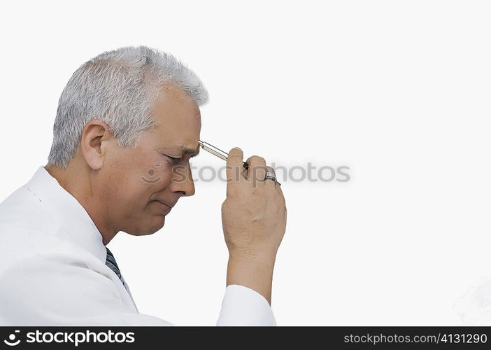 Side profile of a businessman holding a pen and thinking