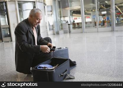 Side profile of a businessman packing his suitcase at an airport