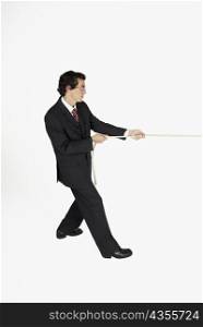 Side profile of a businessman pulling a rope