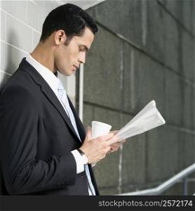 Side profile of a businessman reading a newspaper