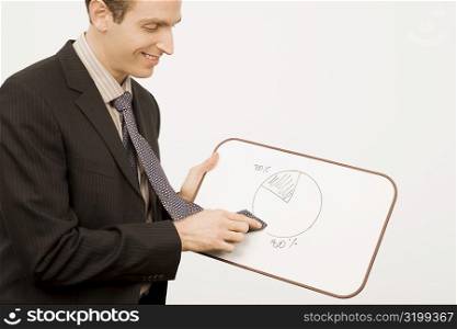 Side profile of a businessman rubbing pie chart with his tie and smiling