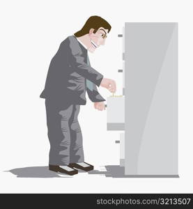 Side profile of a businessman searching for documents in a filling cabinet