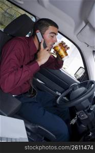 Side profile of a businessman sitting in a car and drinking cold drink