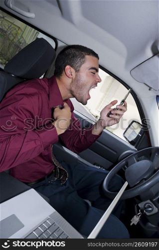 Side profile of a businessman sitting in a car and shouting