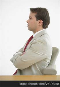 Side profile of a businessman sitting with his arms crossed