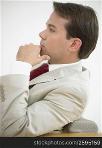 Side profile of a businessman thinking with his hand on his chin