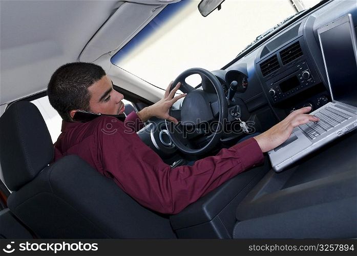 Side profile of a businessman using a laptop in a car