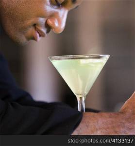 Side profile of a businessman with a martini in front of him