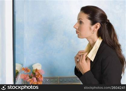Side profile of a businesswoman adjusting collar of her shirts