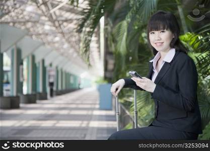 Side profile of a businesswoman and holding a mobile phone
