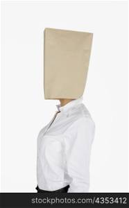 Side profile of a businesswoman covering her face with a paper bag