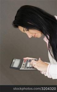 Side profile of a businesswoman holding a calculator
