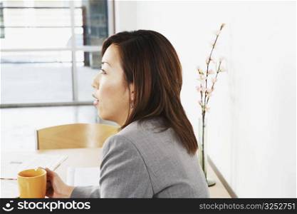 Side profile of a businesswoman holding a cup