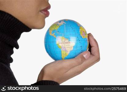 Side profile of a businesswoman holding a globe