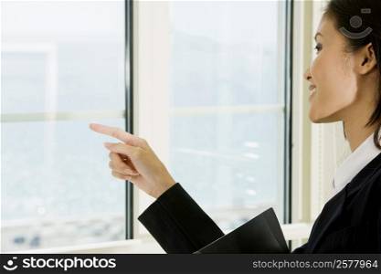 Side profile of a businesswoman looking through a window